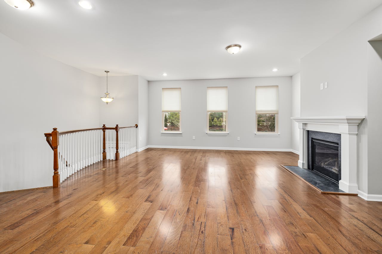 why-choose-us Bright and spacious modern living room with wooden floors and a fireplace, perfect for interior design inspiration.