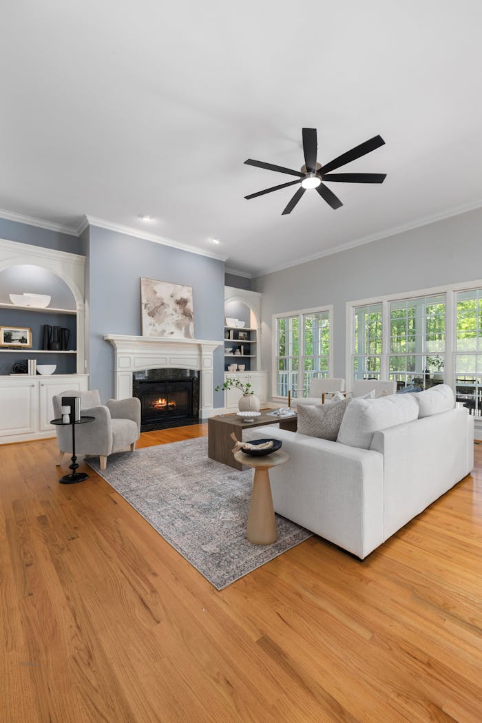 Elegant living room featuring a modern design with a fireplace and large windows.